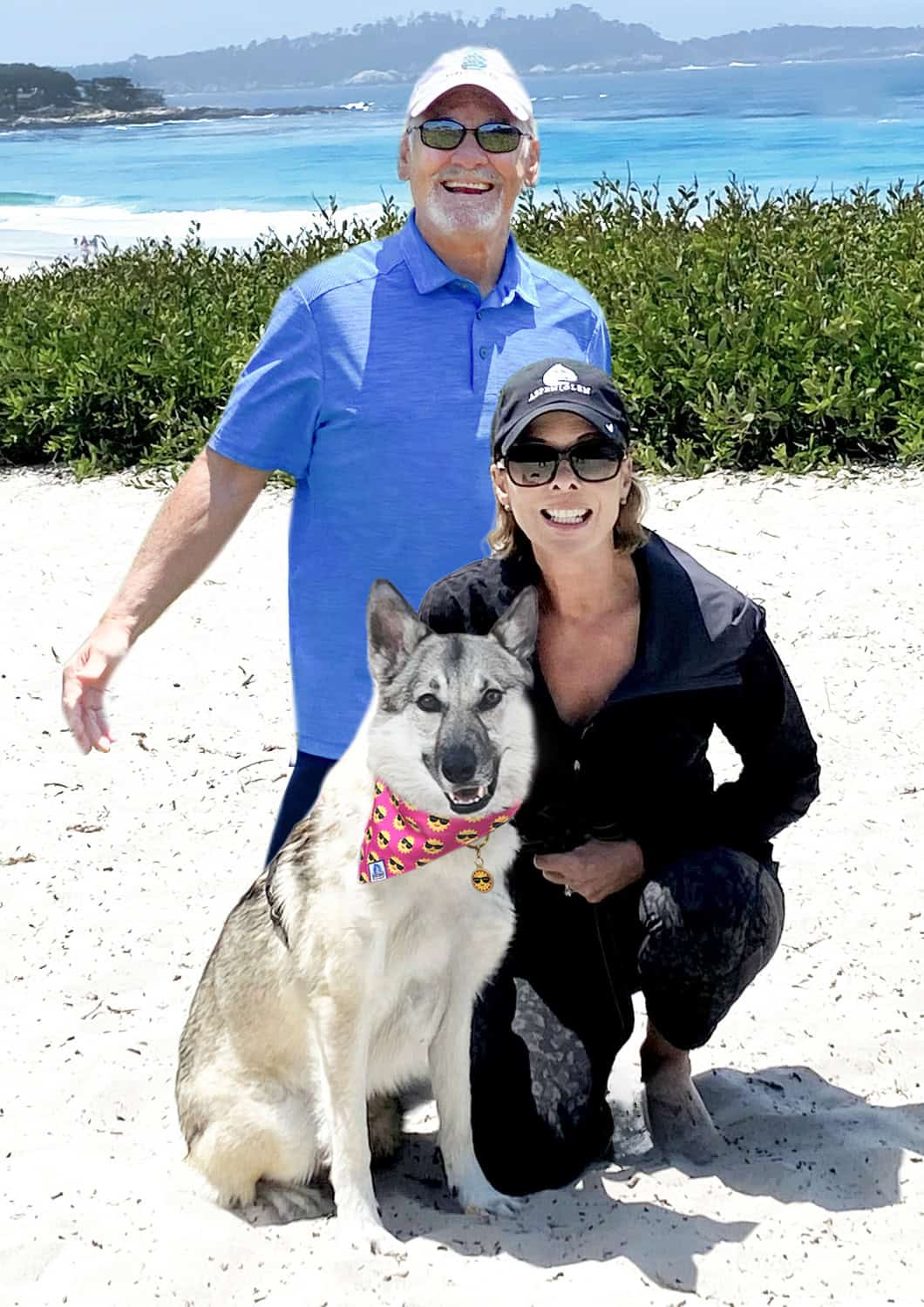 A couple and their dog stand together on a sunlit beach, symbolizing the beginning of our journey and the love that inspired our brand.